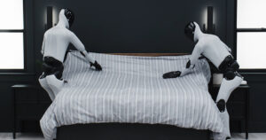 Deux humanoides Figure 02 font un lit ensemble dans une chambre lors de la demonstration Helix 02 du 9 mai 2026