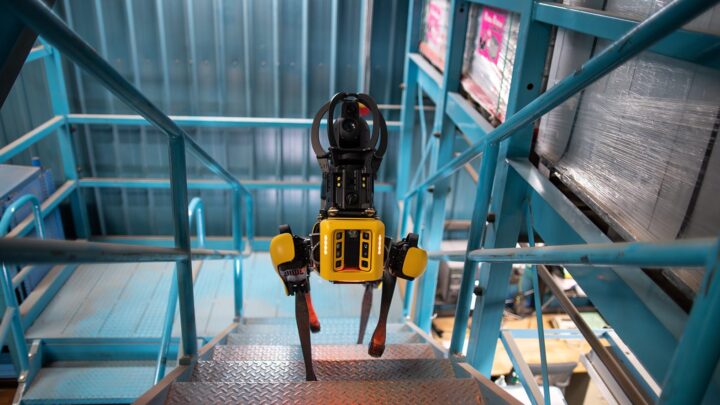 Robot quadrupède Spot de Boston Dynamics montant un escalier dans une installation industrielle