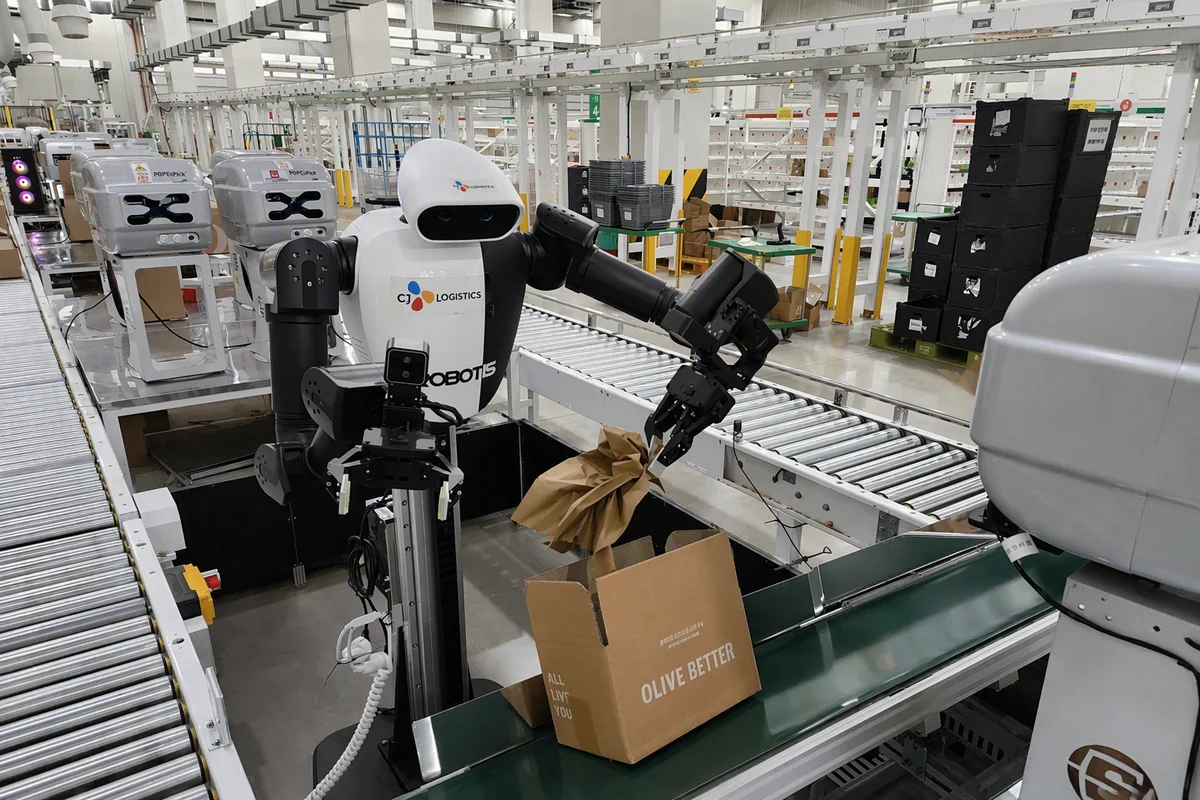 Robot humanoïde à deux bras plaçant du papier de calage dans un colis chez CJ Logistics