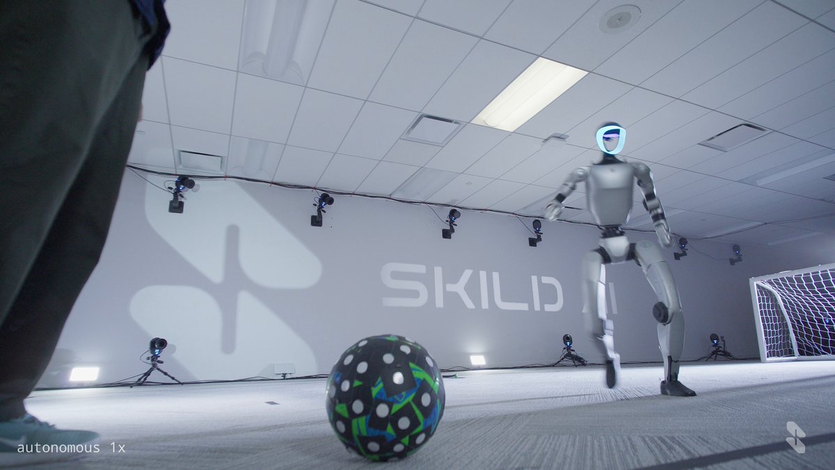 Robot humanoïde de Skild AI jouant au football sur un terrain intérieur