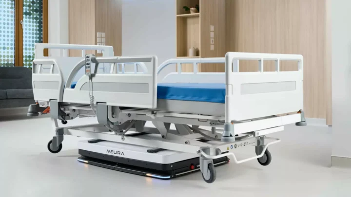 Robot mobile autonome Neura soulevant un lit vide dans une chambre d’hôpital