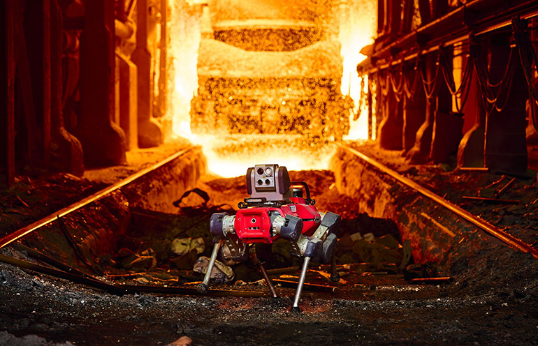 Le robot quadrupède ANYmal X devant une coulée de métal dans un site industriel