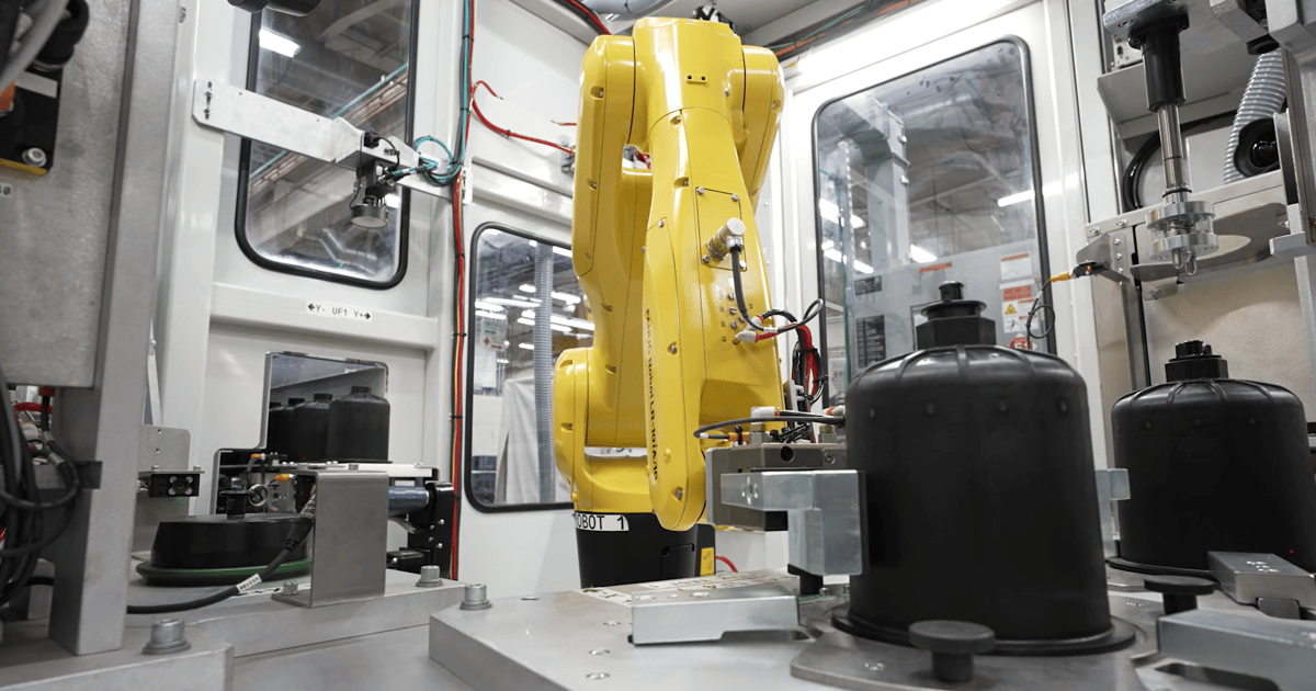 Robot industriel jaune FANUC dans la cellule automatisée de fabrication de filtres Atmus